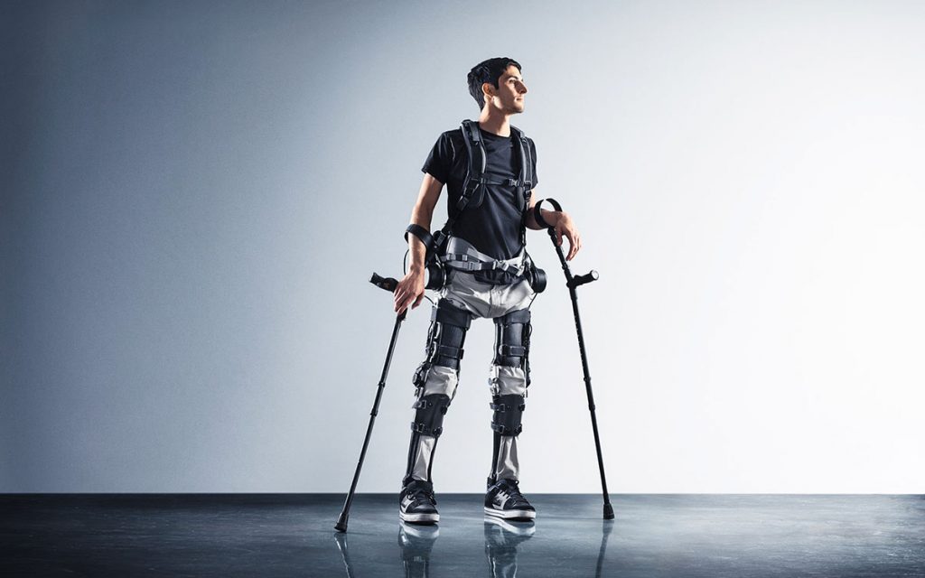 A man with braces around his leg and two metal crutches.