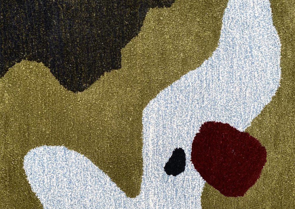 Tufted rug featuring green, blue, and maroon
