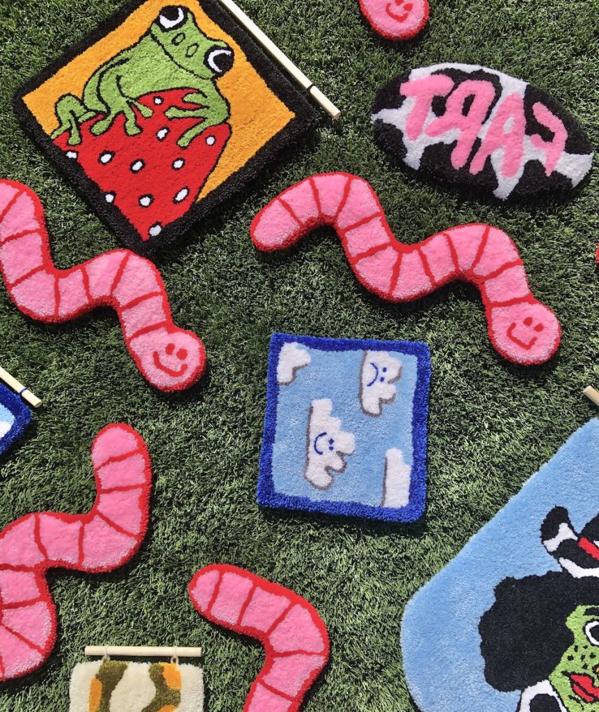 Array of tufted rugs spread across grass