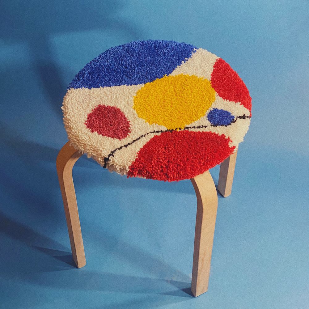 Tufted stool covering in primary colors